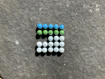 Colourful marbles arranged on a five by five grid. The first row is filled with blue marbles. The second row is filled with green marbles. In the third row the first two columns are empty, the remaining columns are occupied by white marbles. The fourth and fifth rows are filled with white marbles.