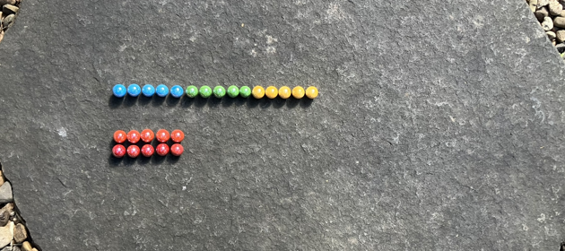 Colourful marbles, arranged on a mostly five by five grid. The first row is fifteen marbles wide, the second and third rows are missing, they have been moved to the first row.